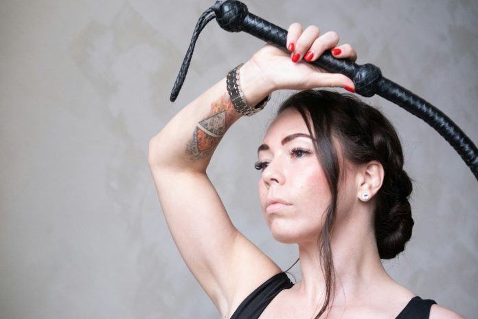 Photo by Cord Allman a woman with a tattoo on her arm holding a hair dryer
